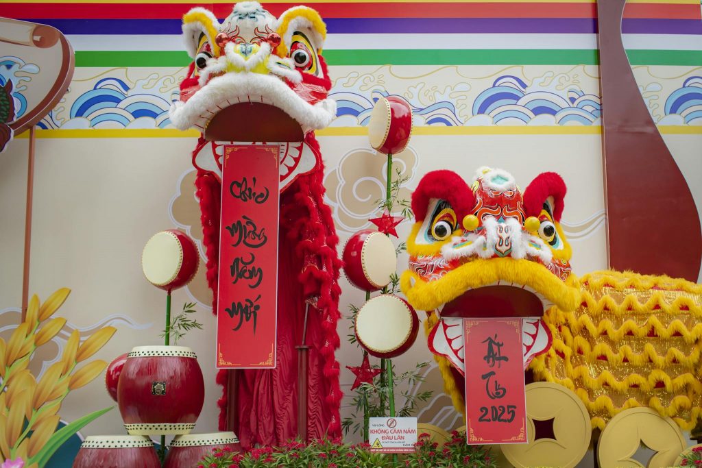 Colorful lion dance costumes with drums at a festive Asian celebration.